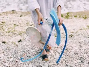 Woman clearing beach area of litter